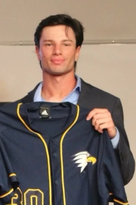 Jake Discount holding his college baseball jersey